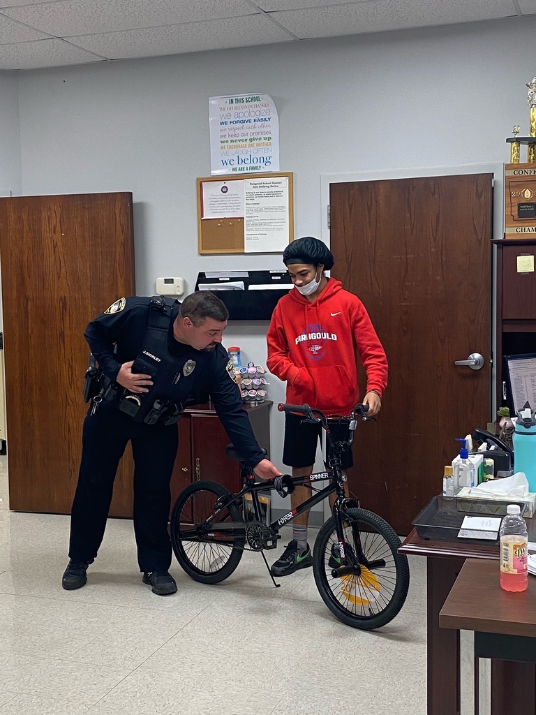 Cpl Shirley giving a bike to a student