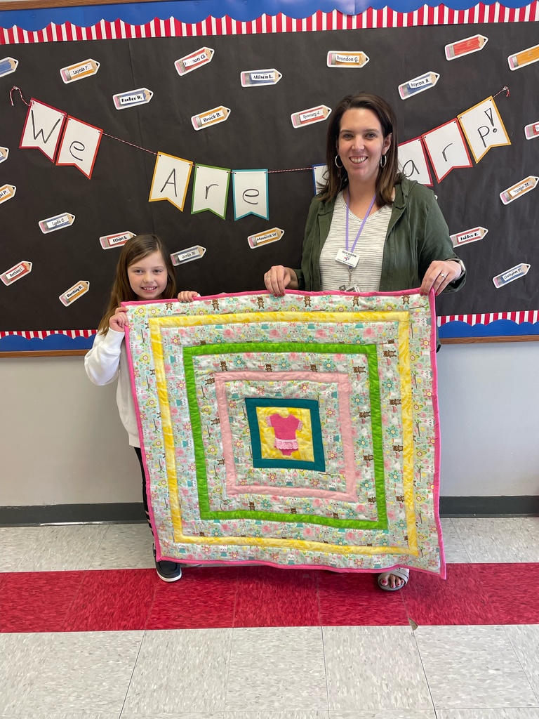 Ava Shirley gifting a homemade quilt to her teacher, Julia Sleeper